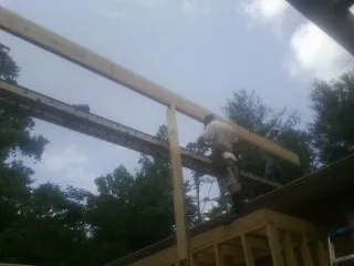Carpenter setting a ridge beam over a new addition frame — Ice Dam Removal by Roofing Brothers in Walnutport