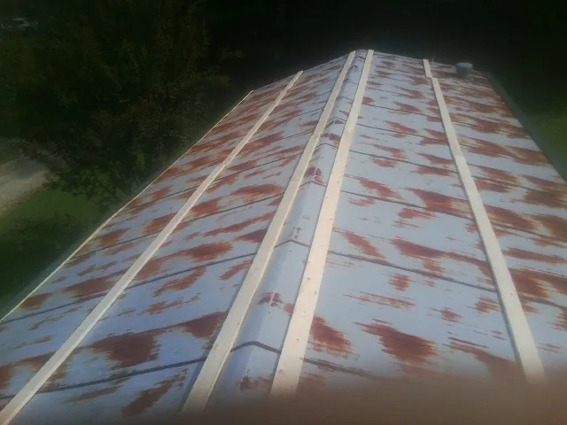 Rusted metal roof panels with new wood purlins before replacement — Storm Damage Roof Repair in Walnutport by Roofing Brothers