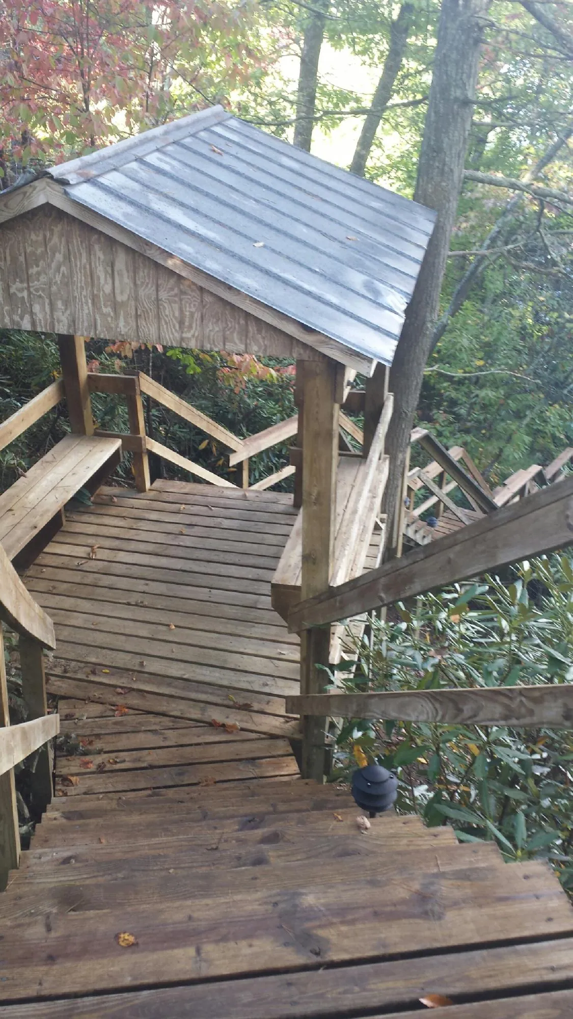 Metal roofed shelter over wooden steps on a wooded walkway — Skylight Repair & Installation work by our crew in Walnutport