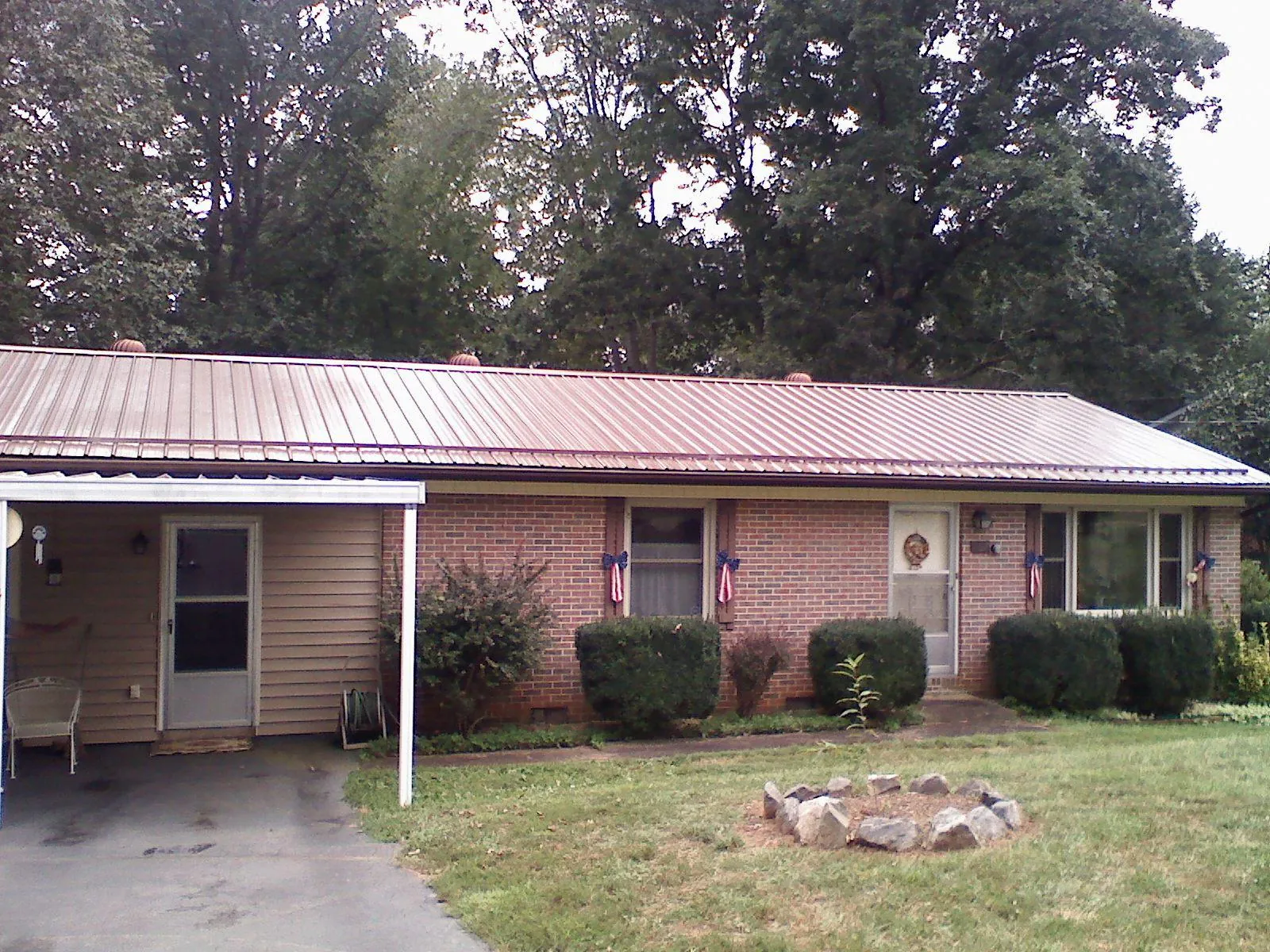 Bronze metal roof and carport on a brick ranch home — Roof Repair work by our crew in Walnutport
